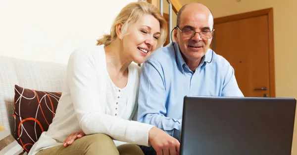 senior couple looking at laptop screen