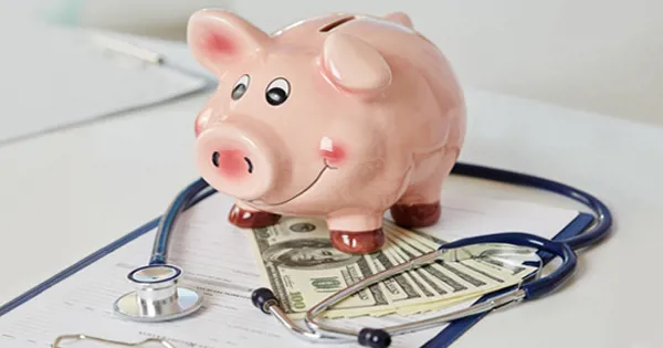 piggy bank on money and stethoscope