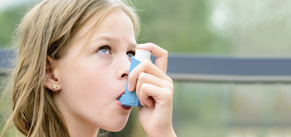 girl using asthma inhaler