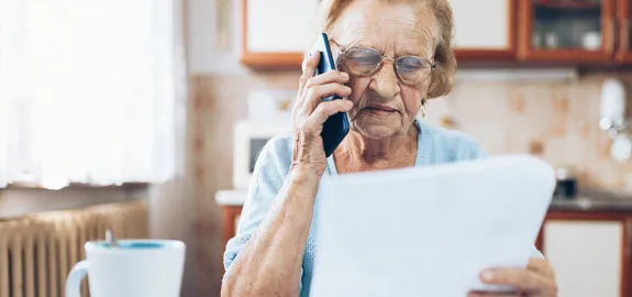 Woman on phone holding bill